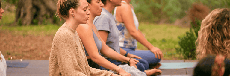 Cilvēki meditē pie dabas