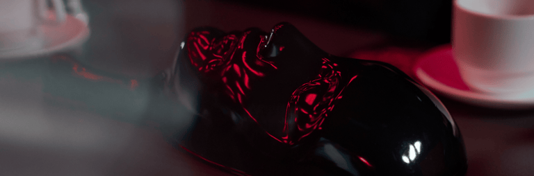 Mistiska maska uz galda ar tējas krūzem