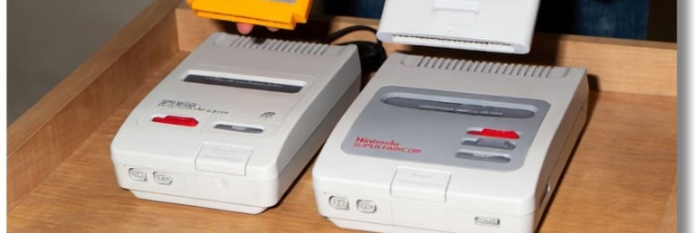 Adaptador Famicom com um cartucho amarelo (esquerda) Super Famicom com um cartucho (direita)