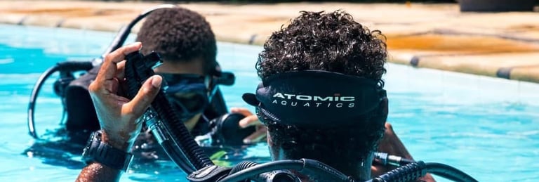 two people in scuba diving suits in a pool