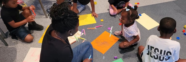 a group of children sitting on the floor in a circle drawing