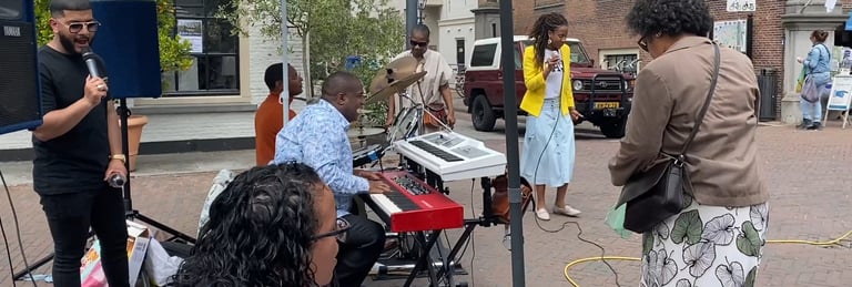 a group of people standing around a piano outside singing