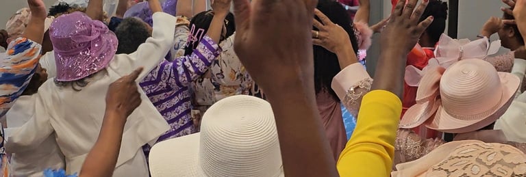 a group of women in hats and hands lifted up
