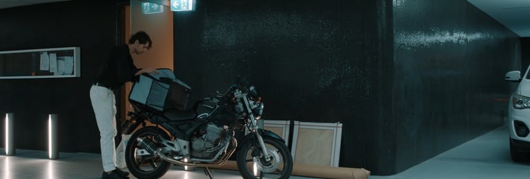 a man standing next to a motorcycle in a garage