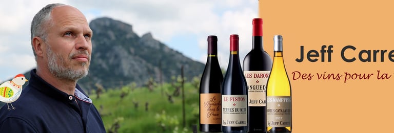 Winemaker Jeff Carrel next to a selection of his French red and white wine bottles.
