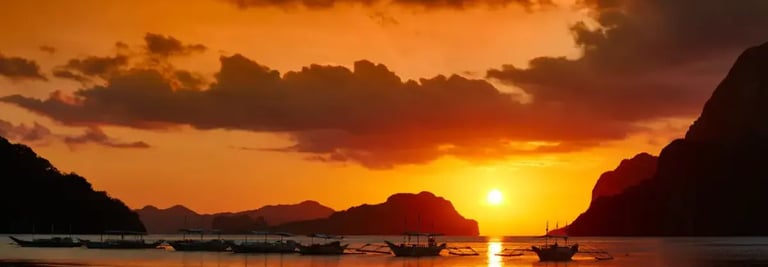 Traditional boat sailing in El Nido bay during a golden sunset dinner cruise