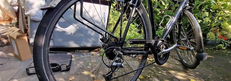 Fietsreparatie aan het achterband van een fiets in Amsterdam