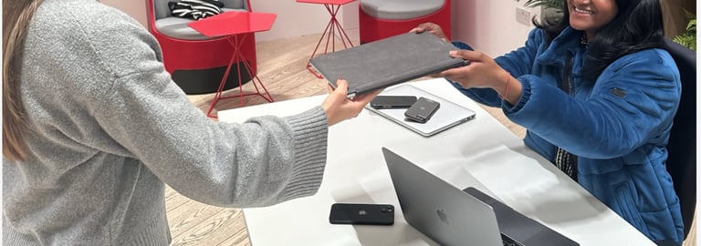 A customer hands a laptop to a member of our team at a TTB CircularIT tech amnesty event