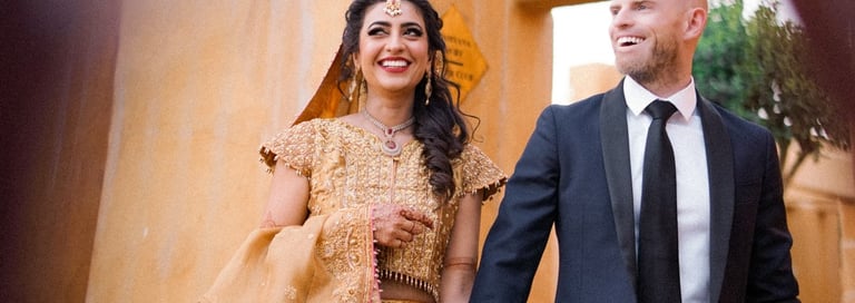 a man and woman holding hands and walking through a doorway
