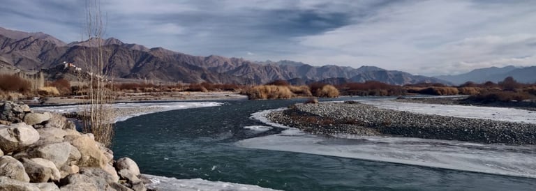 a river with ice and snow on the ground