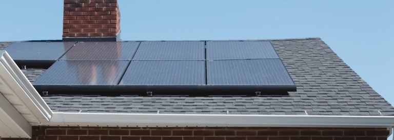 a house with a solar paneled roof and a lawn chair