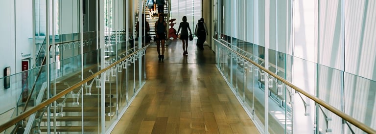 Lichte schoolhal met glas en ruimte, symbool voor openheid en reflectie in digitalisering.