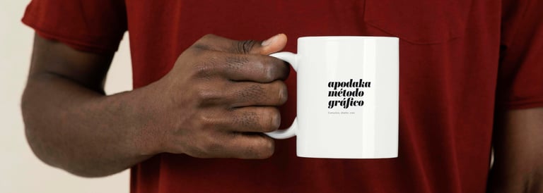 Persona sosteniendo una taza blanca con el logotipo Apodaka Método Gráfico
