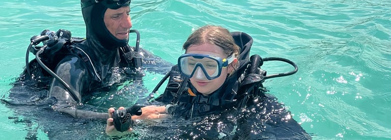a man and woman in scuba gear in the water