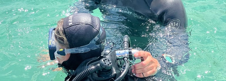 a man and a woman in scuba gear in the water