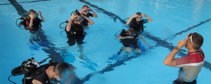 a group of scuba divers in a pool