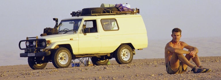 Koos van der Lende on location in Southern Africa, resting beside his 4x4 expedition vehicle during an expedition.