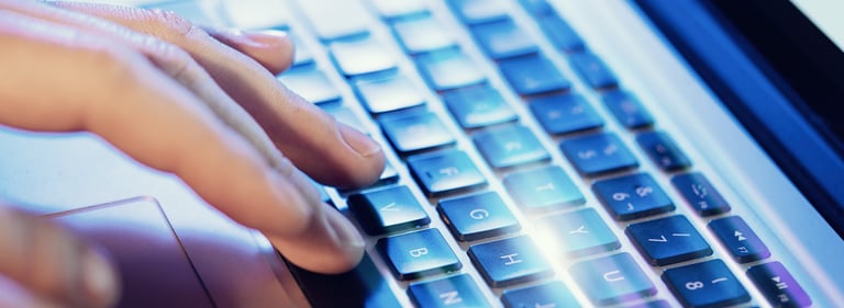 Fingers on a computer keyboard beginning to type