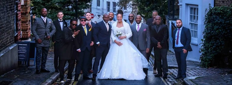 newly-weds posing on a Hampstead street with their wedding guests