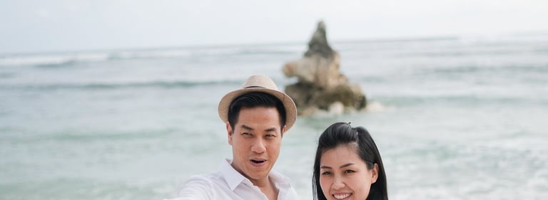 Couple standing together in front of the ocean at Melasti Beach Bali during a relaxed beach portrait session