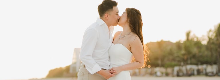 Couple kissing during a sunset beach prewedding photoshoot at Apurva Kempinski Bali