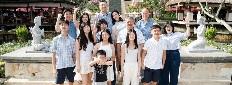 Large extended family portrait in a garden setting captured during a family photography session at Ayana Jimbaran Bali