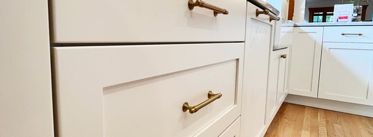 a kitchen with white cabinets and a wooden floor