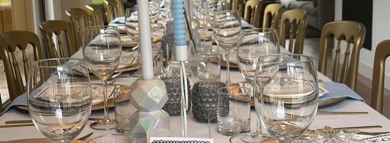 Elegant gedekte tafel met bloemstukken en kaarsen, gestyled door Xagis.