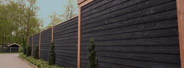 Clôture en bois brut peinte avec une peinture naturelle noire respirante et durable