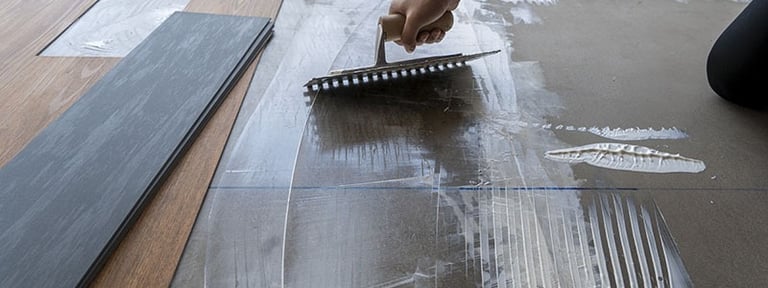 a person is using a brush to remove a floor tile