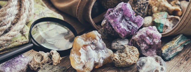 varias piedras preciosas saliendo de un bolso sobre una mesa de madera