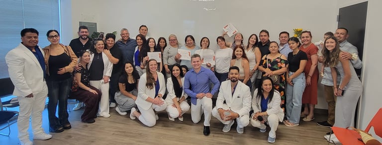A diverse group of smiling graduates holding certificates at a professional certification ceremony.