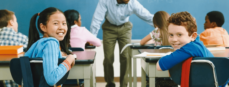 a man standing in front of a classroom with a group of children