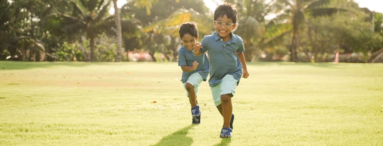 two children running and playing on the lawn at rimba by ayana bali during a bali family photography session