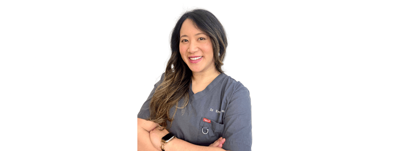a woman in a grey scrubs with an inviting smile