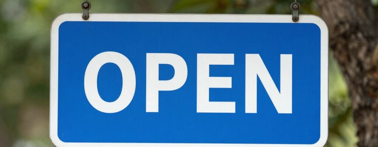 brown and white open signage on green grasses