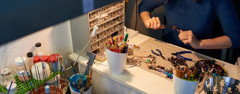 Artesano haciendo joyería con piedras y macramé.