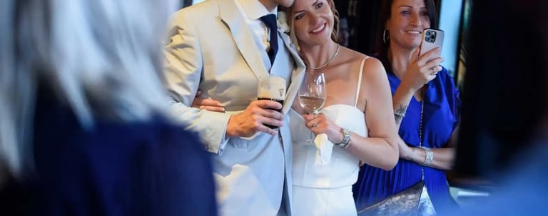 A happy bride and groom celebrate with drinks at their wedding reception venue.