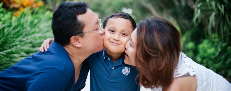 Parents kissing child during family photography session at The Mulia Nusa Dua Bali