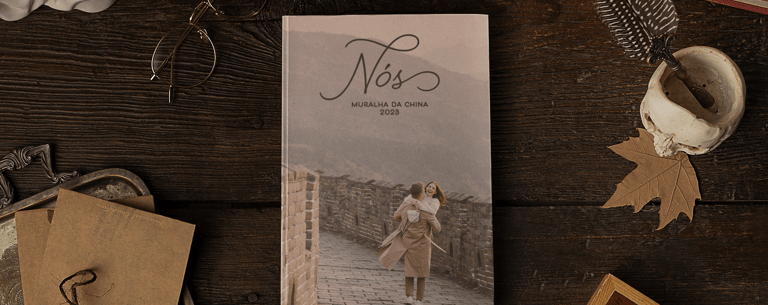 Álbum de viagem da Muralha da China sobre mesa de madeira com objetos vintage.