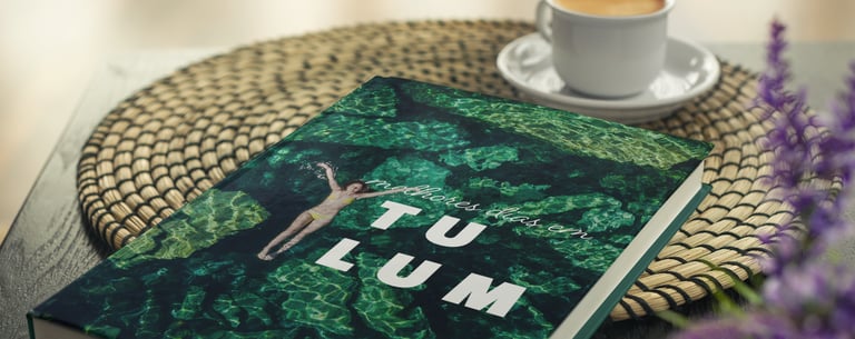 Álbum de viagem de Tulum sobre mesa de centro ao lado de xícara de café.