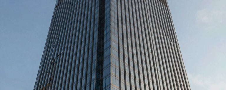 The exterior of a modern glass skyscraper in São Paulo during golden hour, reflecting the blue sky, emphasizing innovation and leadership.