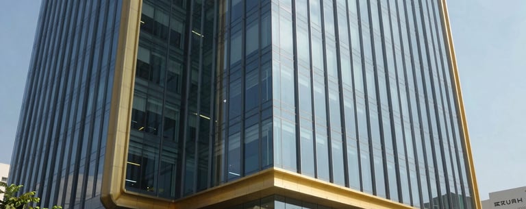 The exterior of a modern office building in Kochi, India, with sleek glass windows and gold trim. Bright, sunny day lighting, professional commercial photography style.
