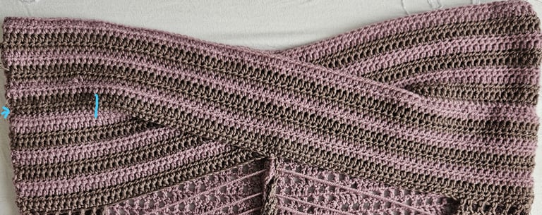 Handmade crochet crop top with a crisscross front design in pink and brown striped yarn.