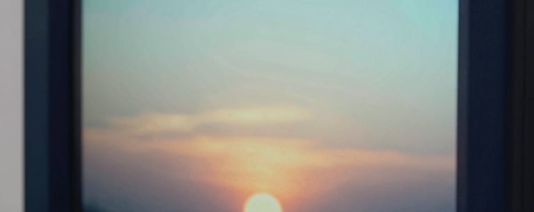 Close-up of a digital display showing a gentle sunset, representing peace and safety. North American aesthetic, clean lines, empathetic mood. Colors: Dark Navy and Light Aqua.