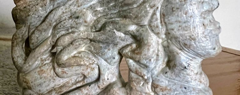 Detail of Soapstone sculpture carved by artist Julie Curson featuring wavy locks emerging from stone