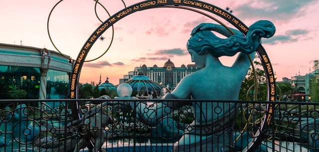 státua feminina de costas com moldura circular inscrita contra o céu rosado em Orlando