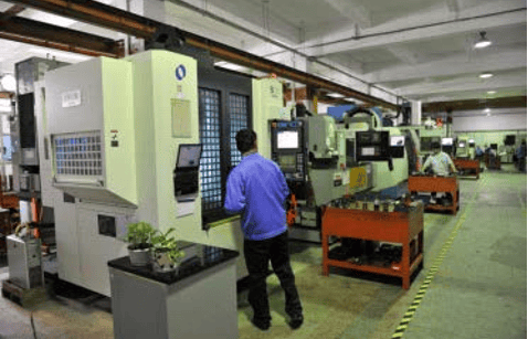 Operators working at CNC milling machines in a modern industrial manufacturing facility.