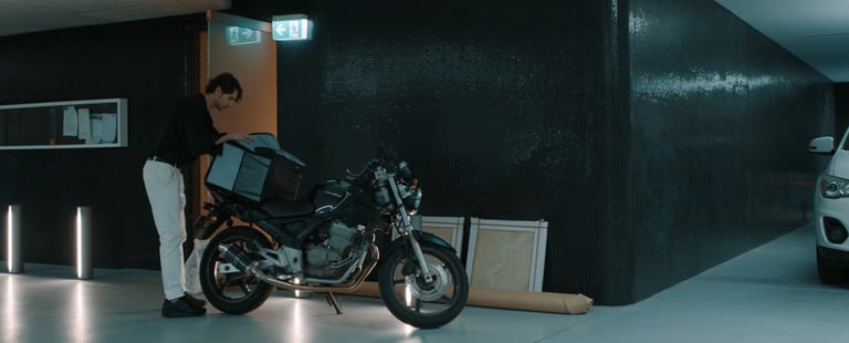 a man standing next to a motorcycle in a garage