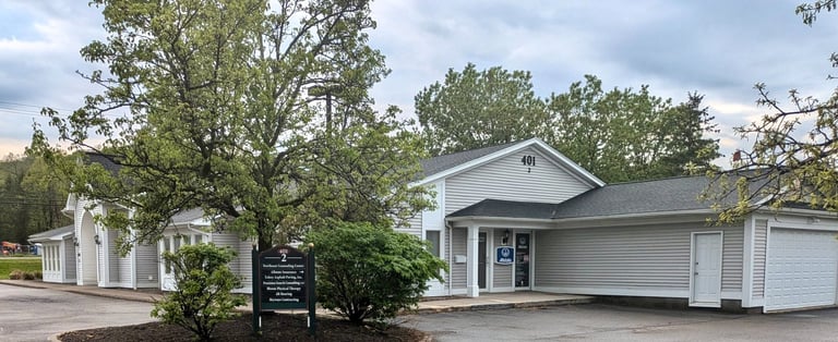 A grey commercial office building with a directory sign and Allstate Insurance office entrance.